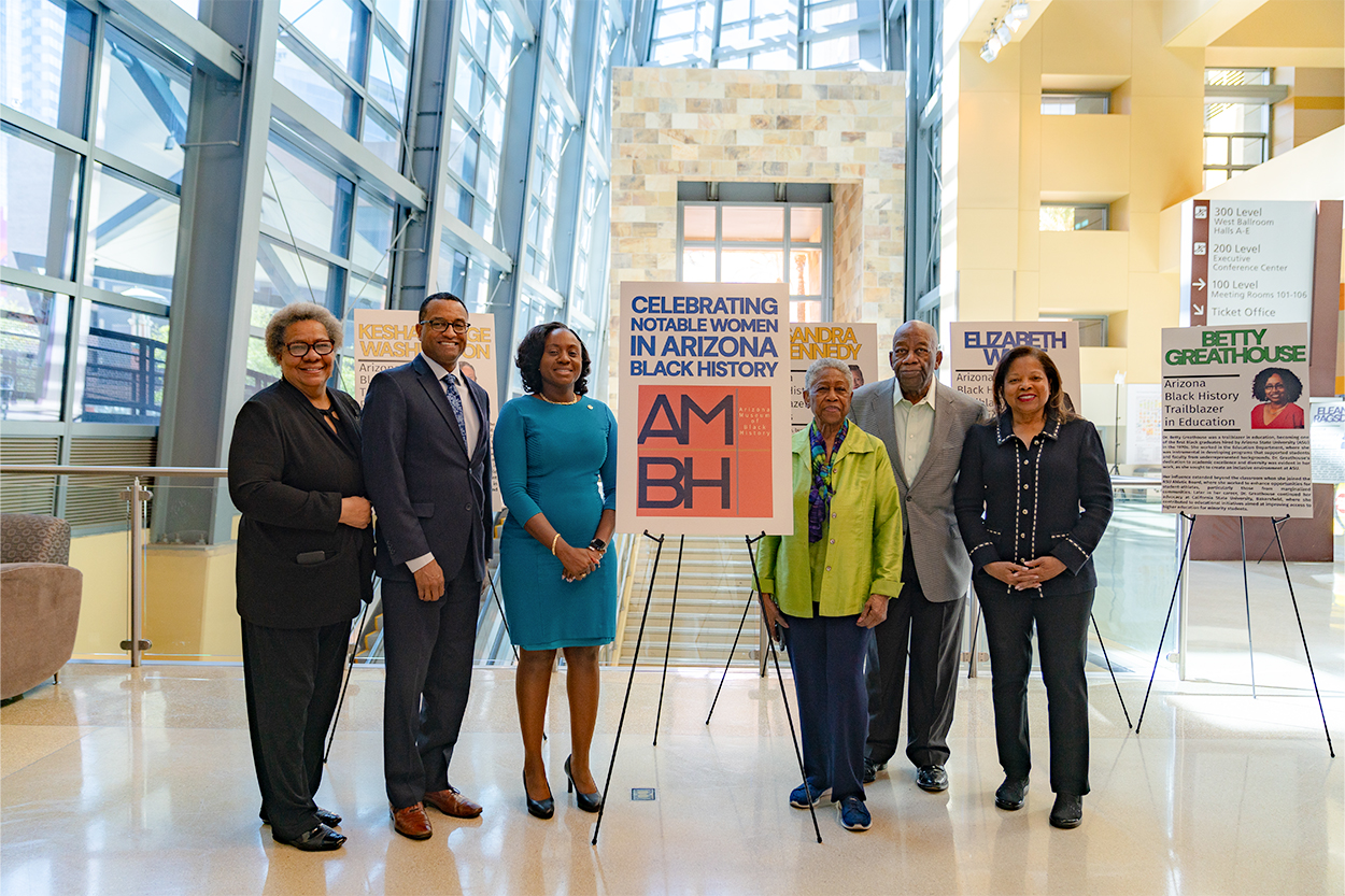 Several people stand in front of an Arizona Black History Museum exhibit at the Phoenix Convention Center