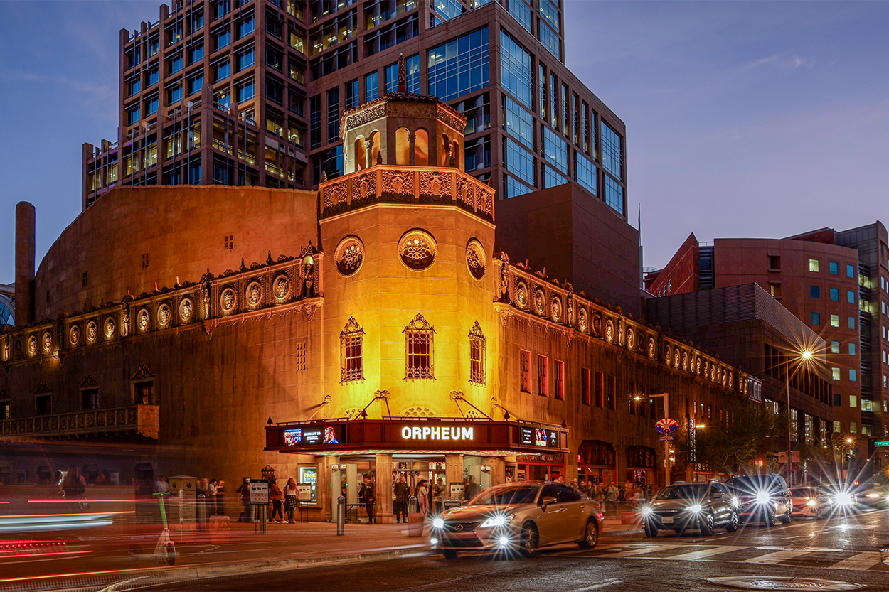The Orpheum Theatre at night with cars driving in front of it.