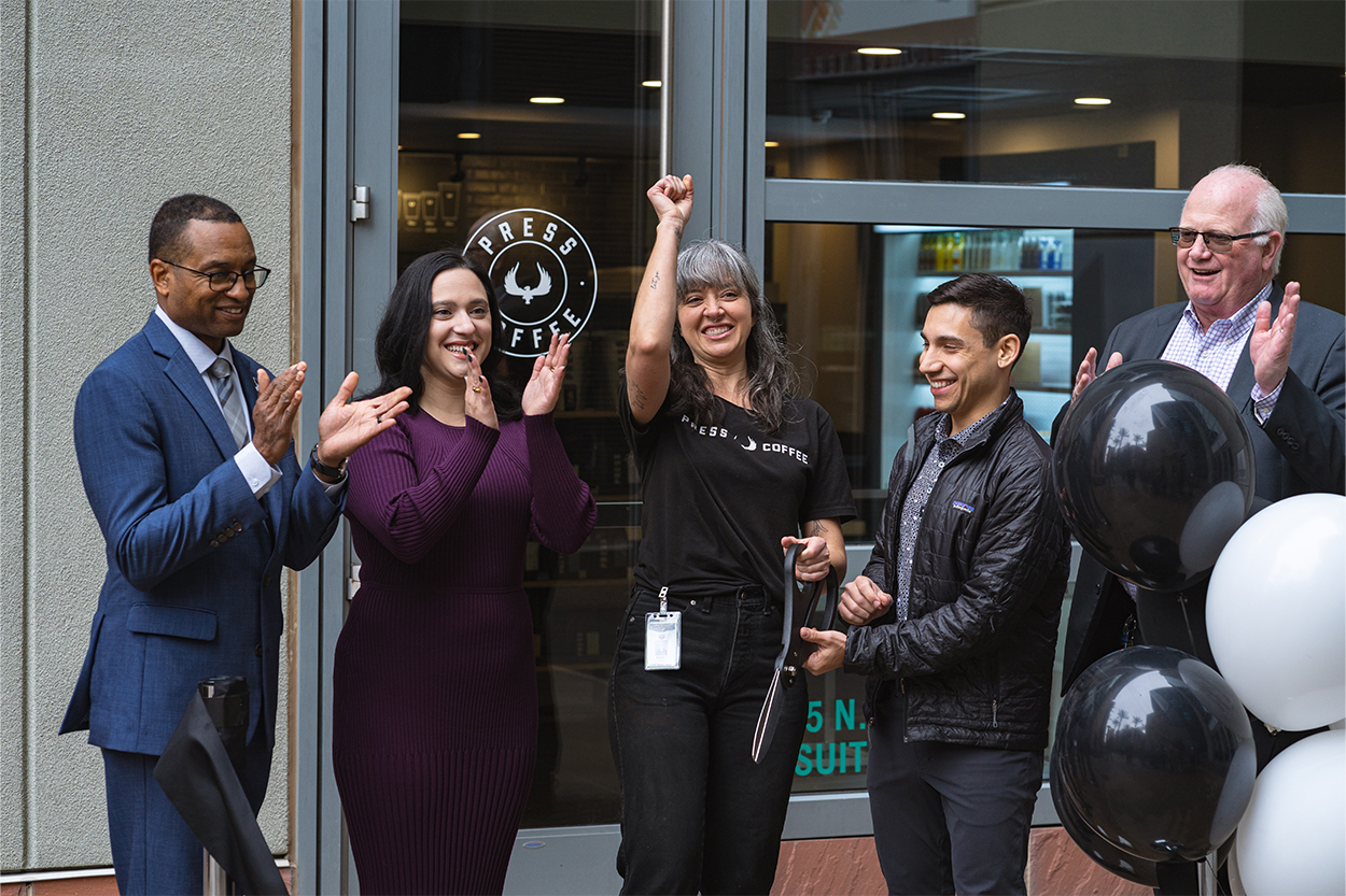 A group of five people clapping during a ribbon cutting ceremony