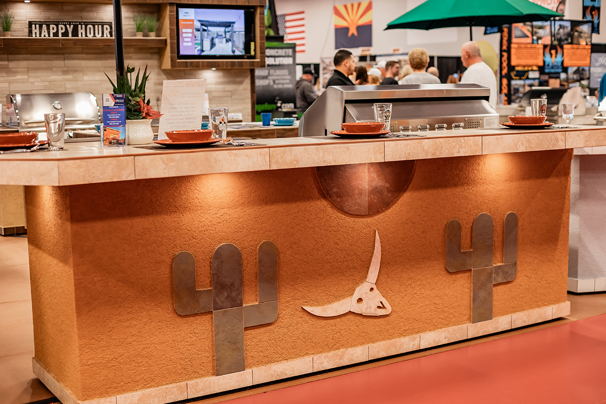 Exhibit booth displaying an outdoor kitchen bar with four table places set